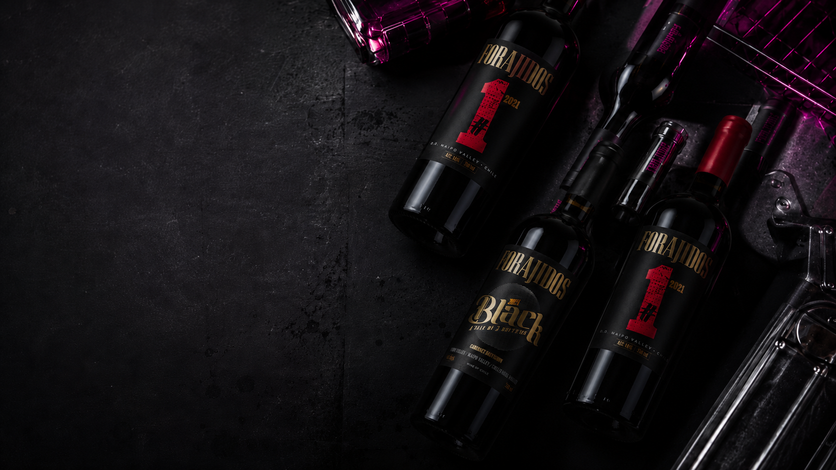Botellas de vino Forajidos sobre una superficie negra
